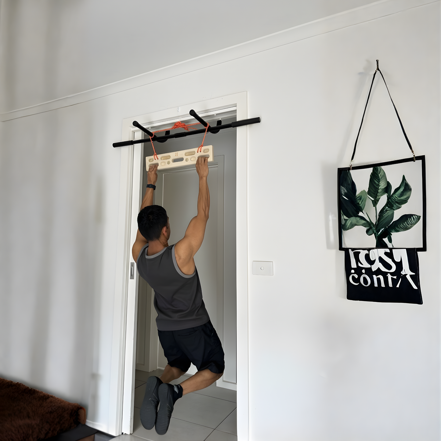 A person using the portable climbing hangboard on a doorframe pull up bar