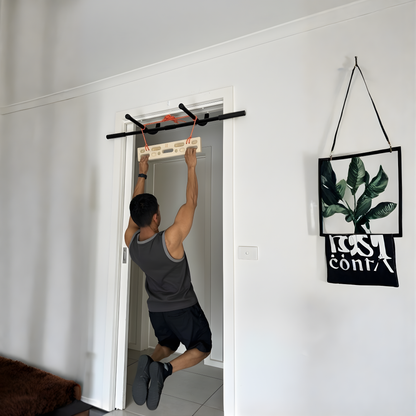 A person using the portable climbing hangboard on a doorframe pull up bar